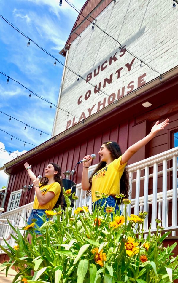Sierra and Anna Shea Safran singing to crowd in courtyard
