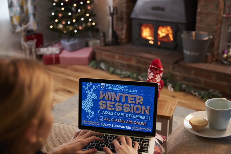 Woman Using Laptop In Room Decorated For Christmas