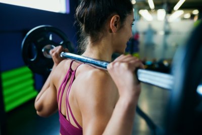 Athletic woman in gym lifting weights at the gym