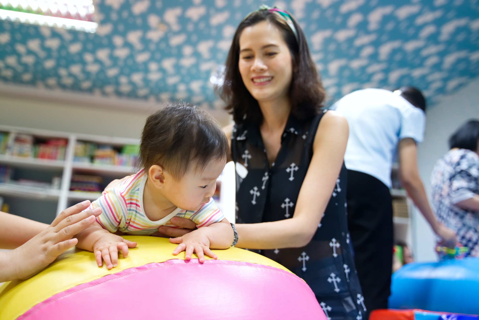 Young little smiling Asian baby enjoy playing in kid playground.