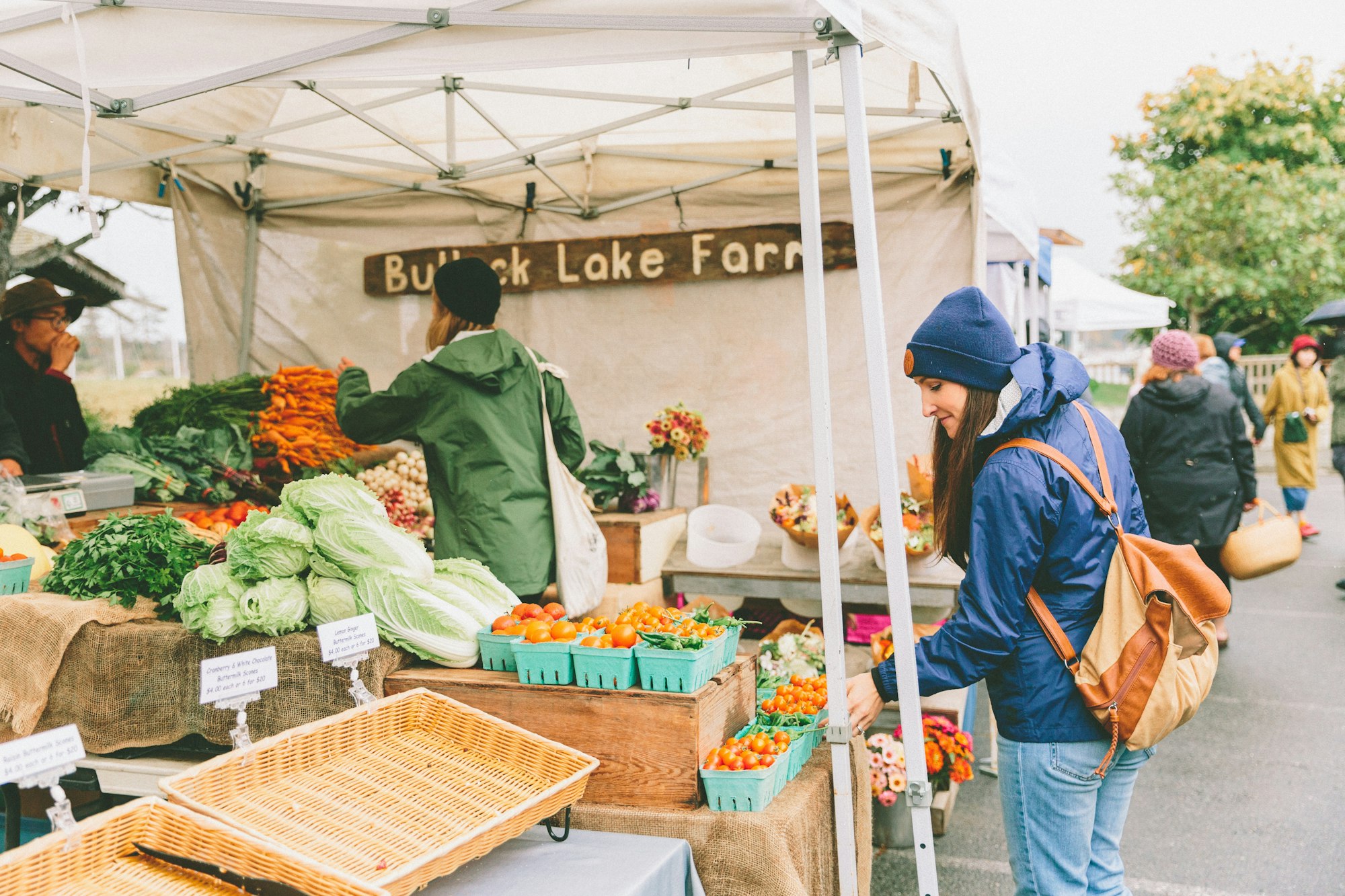 A woman browsing the produce at the farmers market.