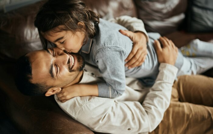 Affectionate Muslim father and daughter embracing at home.