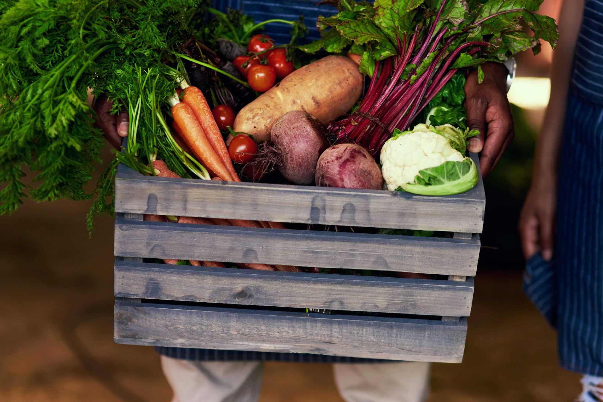 Cropped shot of an unrecognizable farmer holding a crate full of fresh produce at his farm