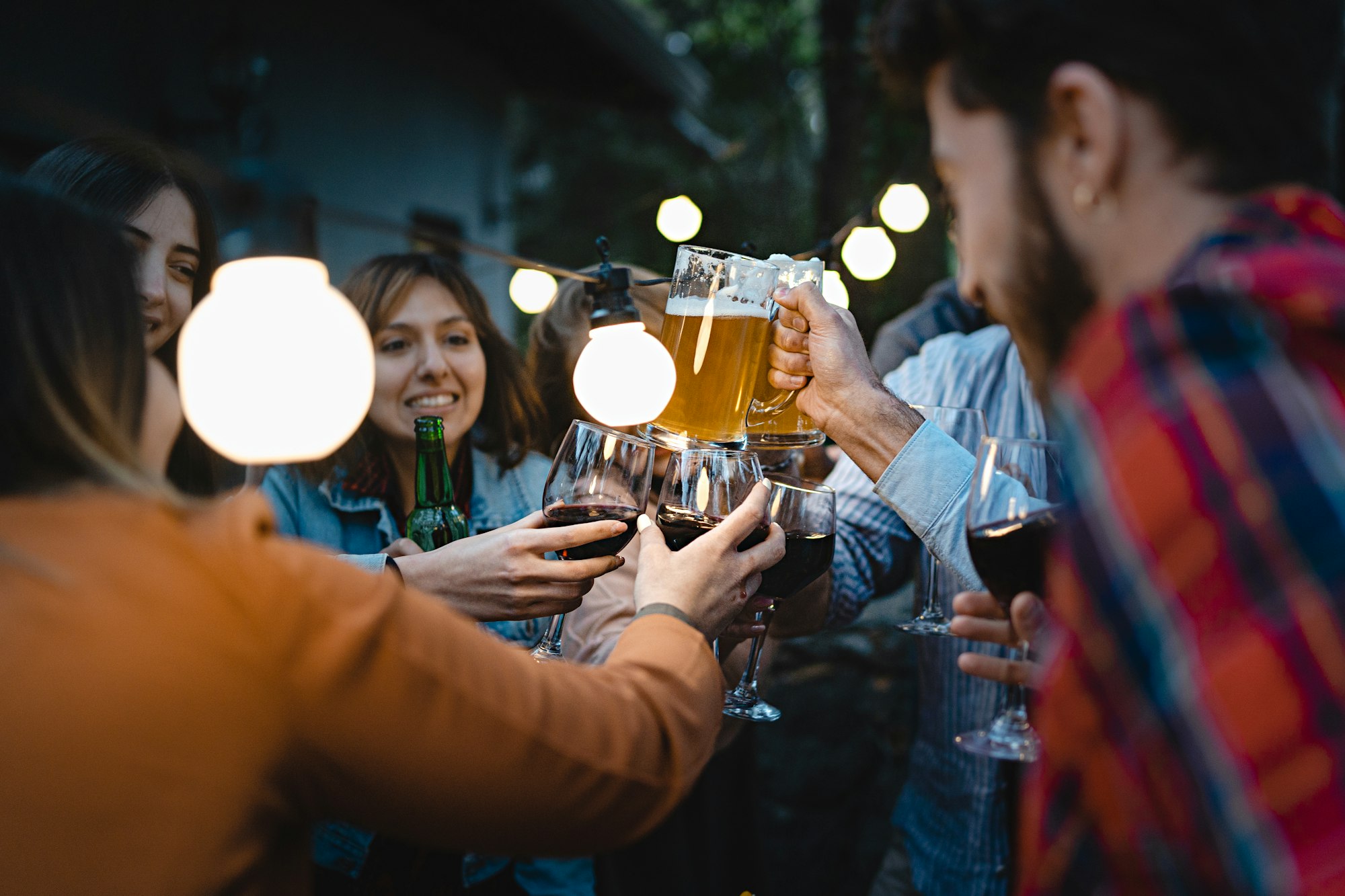Friends toasting beers and wine at the dusk Friends toasting beers and wine at the dusk