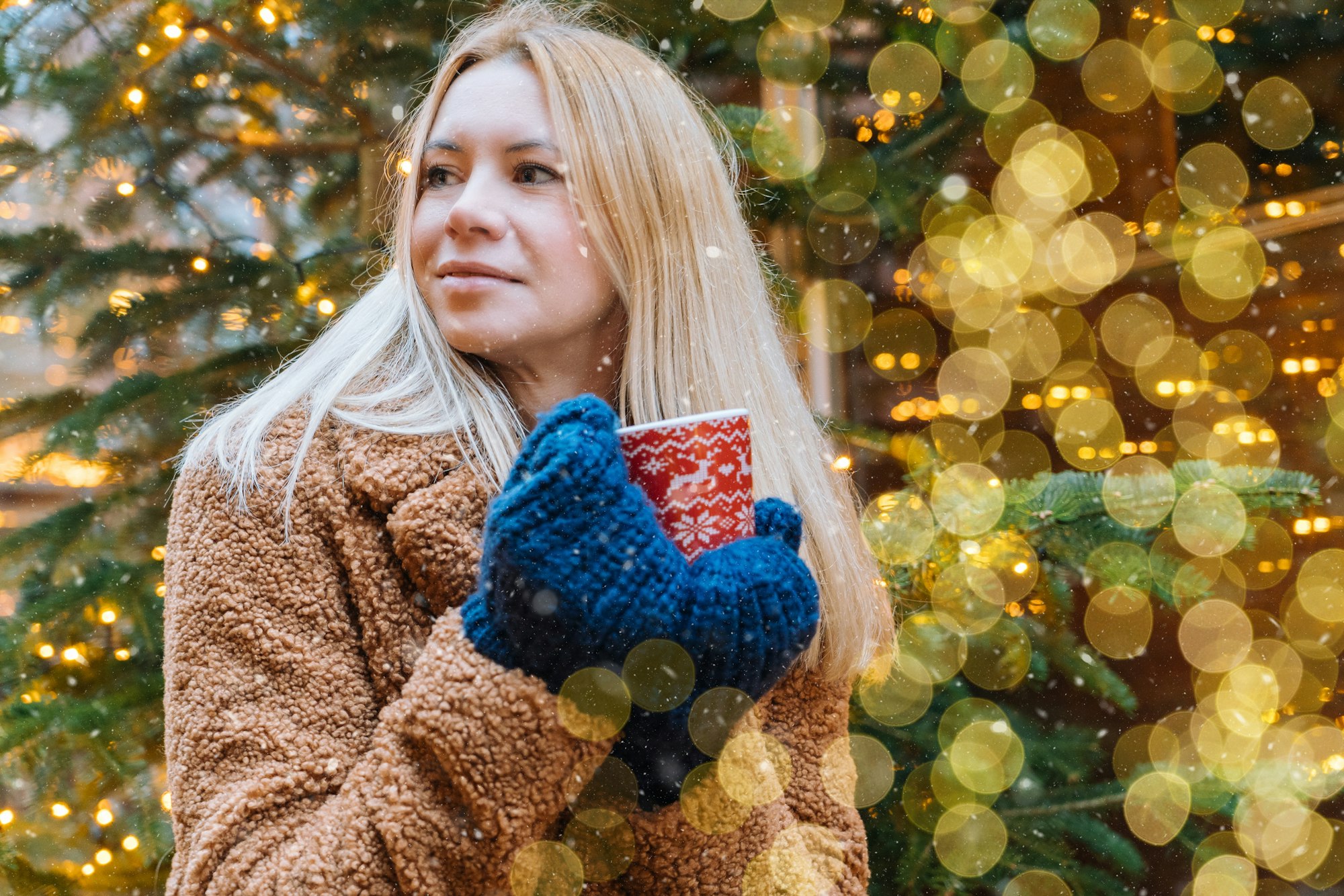 Girl walking in Christmas traditional market decorated with holiday lights in the evening.