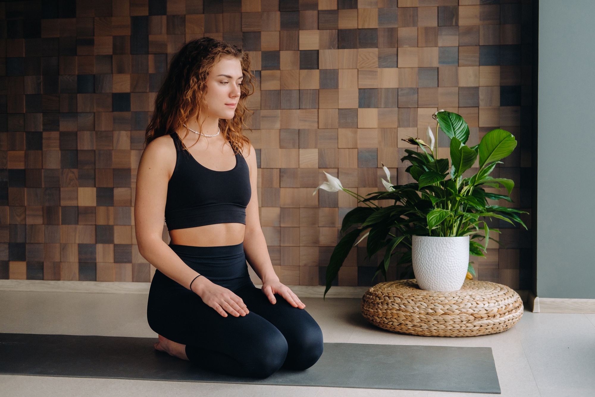 A young woman in black clothes is doing yoga in a modern gym.The concept of health