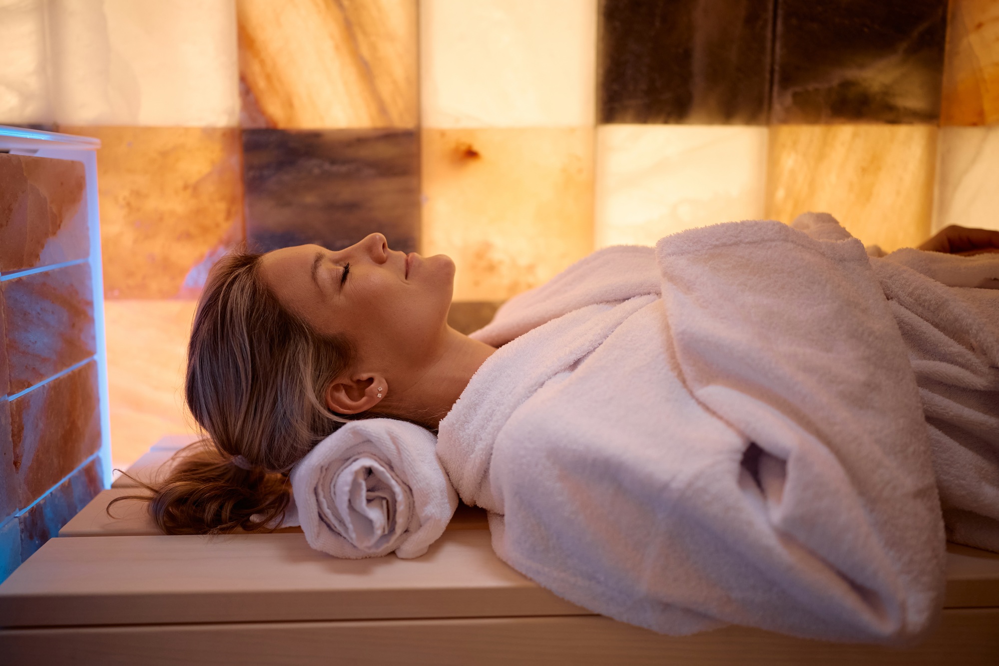 Relaxed woman during halotherapy treatment in salt room.