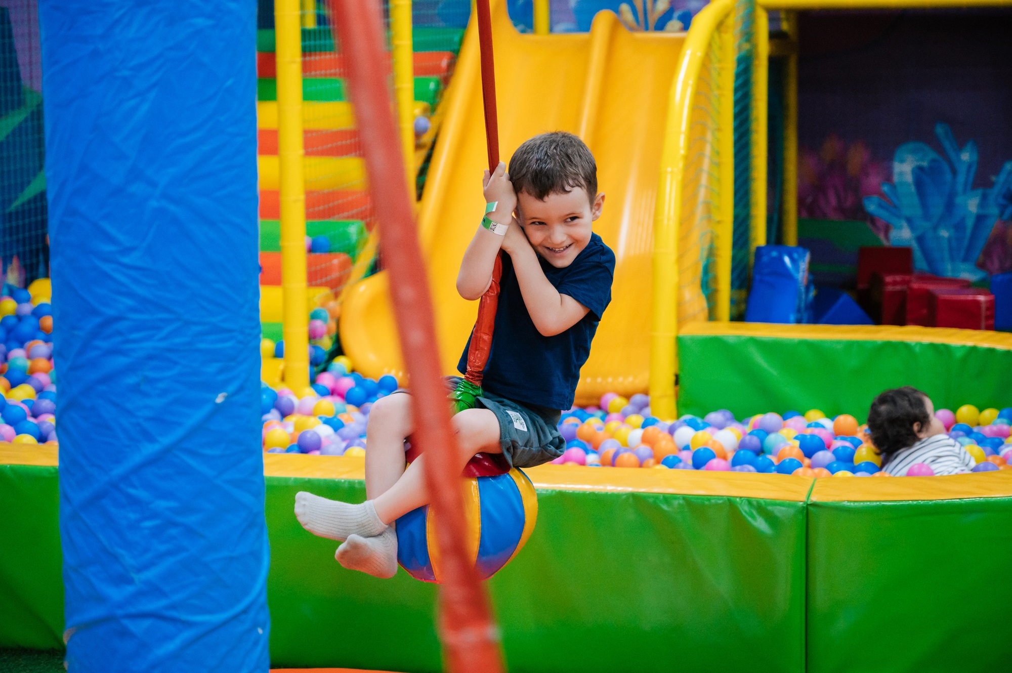 Cute baby boy playing on the playground at the children's play center