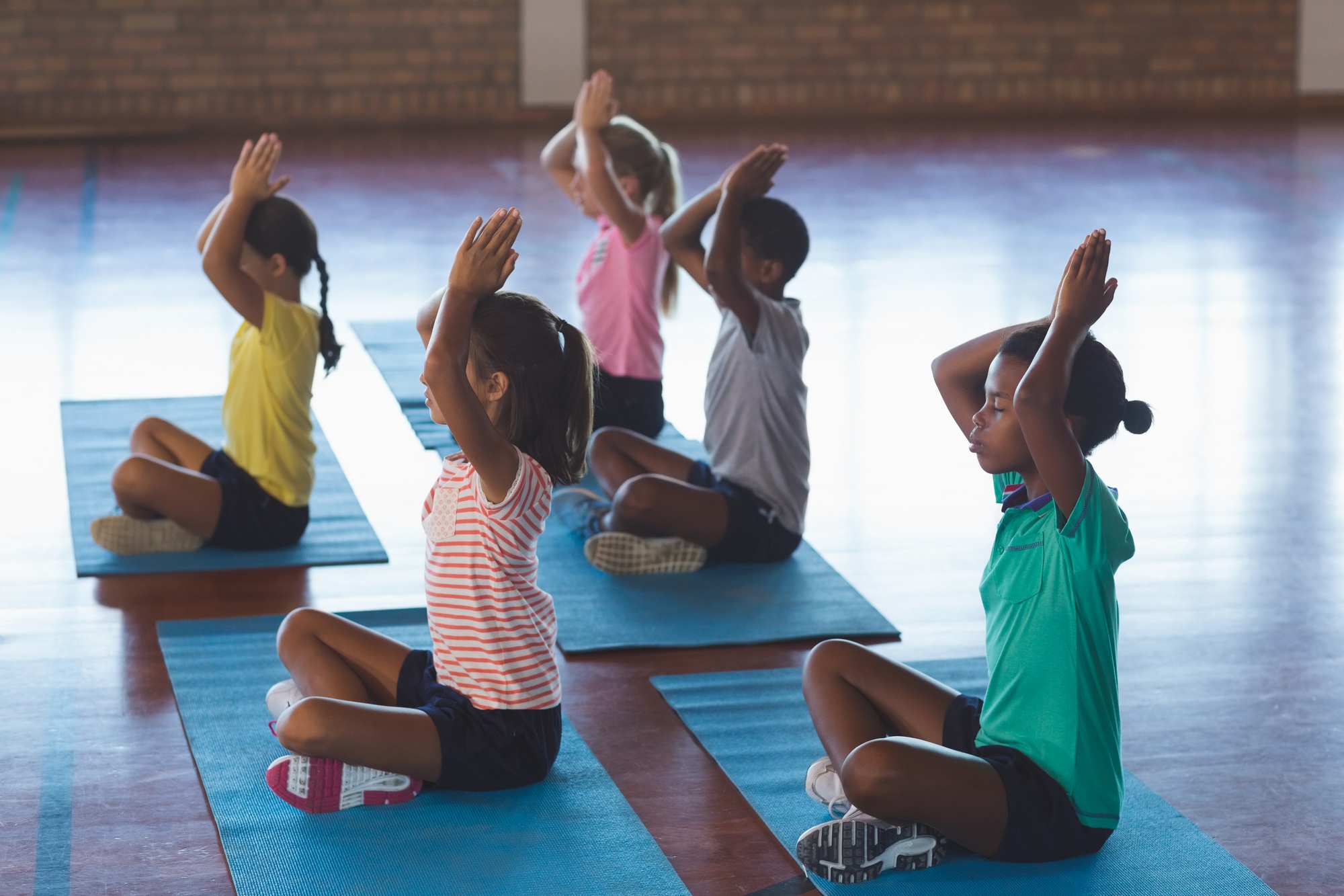 School kids meditating during yoga class