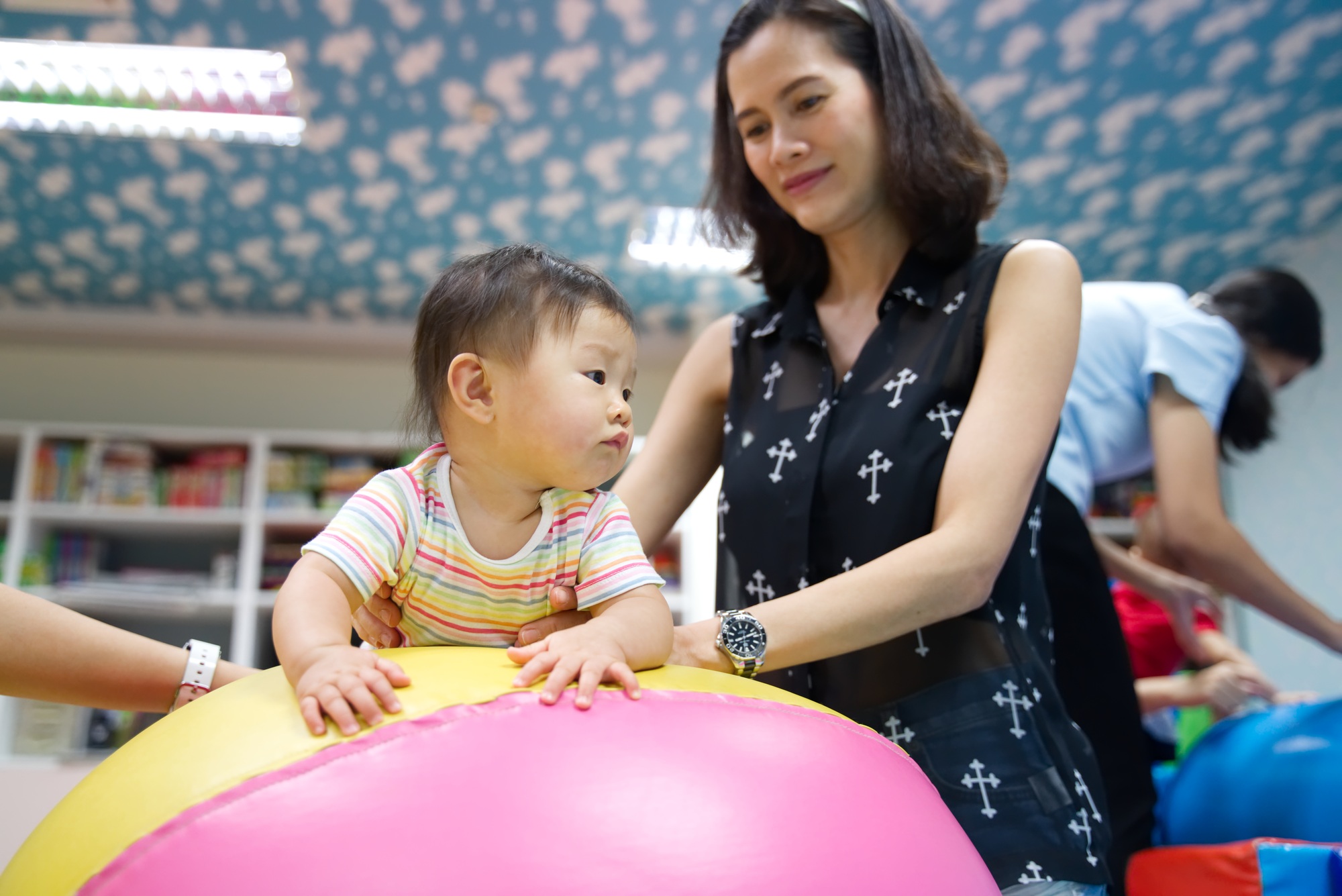 Young little smiling Asian baby enjoy playing in kid playground.