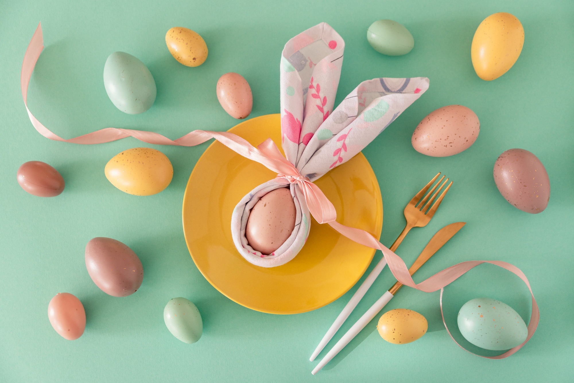 Plate decorated bunny ear napkin, white tulips and Easter eggs on blue background. Plate decorated bunny ear napkin, white tulips and Easter eggs on blue background.