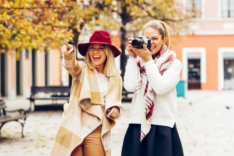Two women tourists taking photos in the city